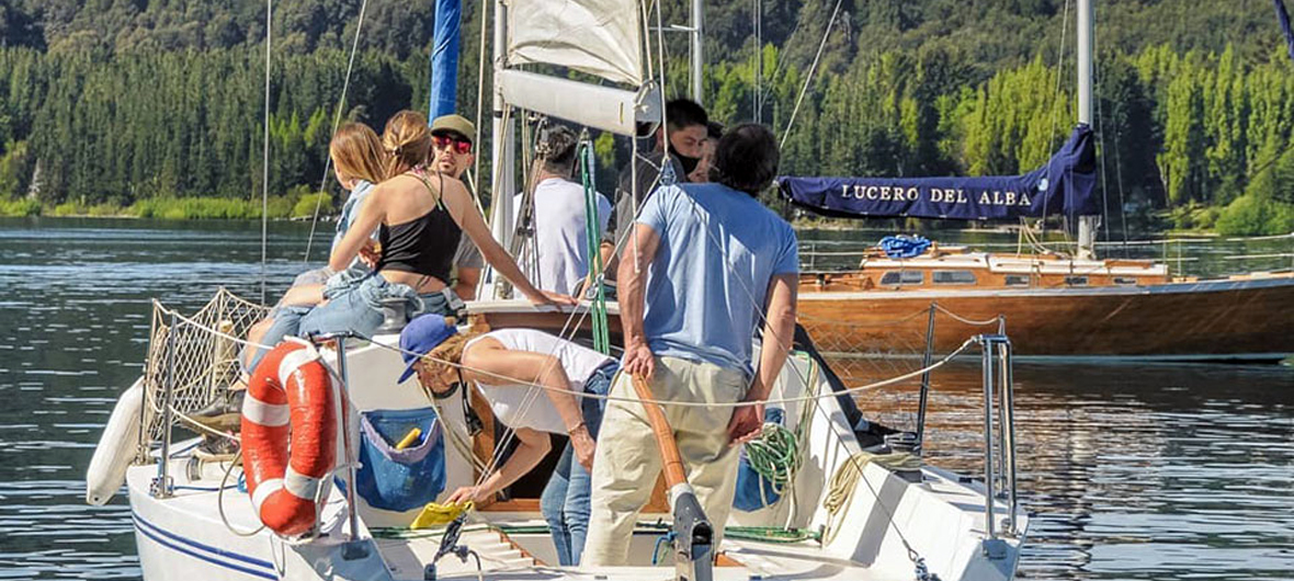 Grupo pequeño de viajeros disfrutando una experiencia íntima de navegación a vela en el Brazo Campanario del Lago Nahuel Huapi, Bariloche, con Diversidad. Turismo Activo & de Naturaleza