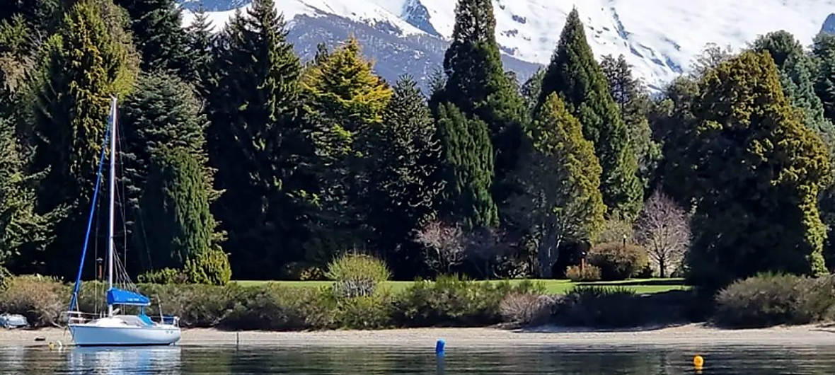 Grupo de viajeros explorando una playa secreta del Lago Nahuel Huapi, Bariloche, tras llegar en un velero de Diversidad. Turismo Activo & de Naturaleza en una experiencia náutica única