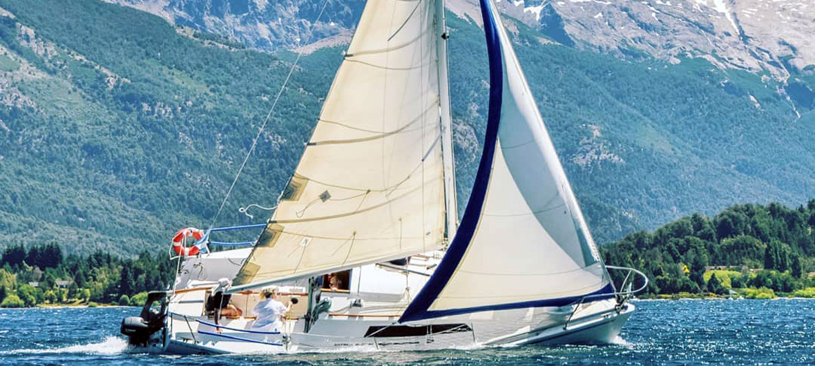 Grupo de viajeros navegando a vela en un velero de Diversidad Turismo por las aguas cristalinas del Brazo Campanario, Lago Nahuel Huapi, Bariloche, en una experiencia náutica auténtica y personalizada